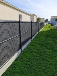 Brise-vue installé sur une clôture rigide